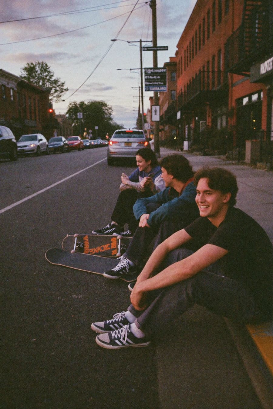 Crew of skaters on a curb at dusk