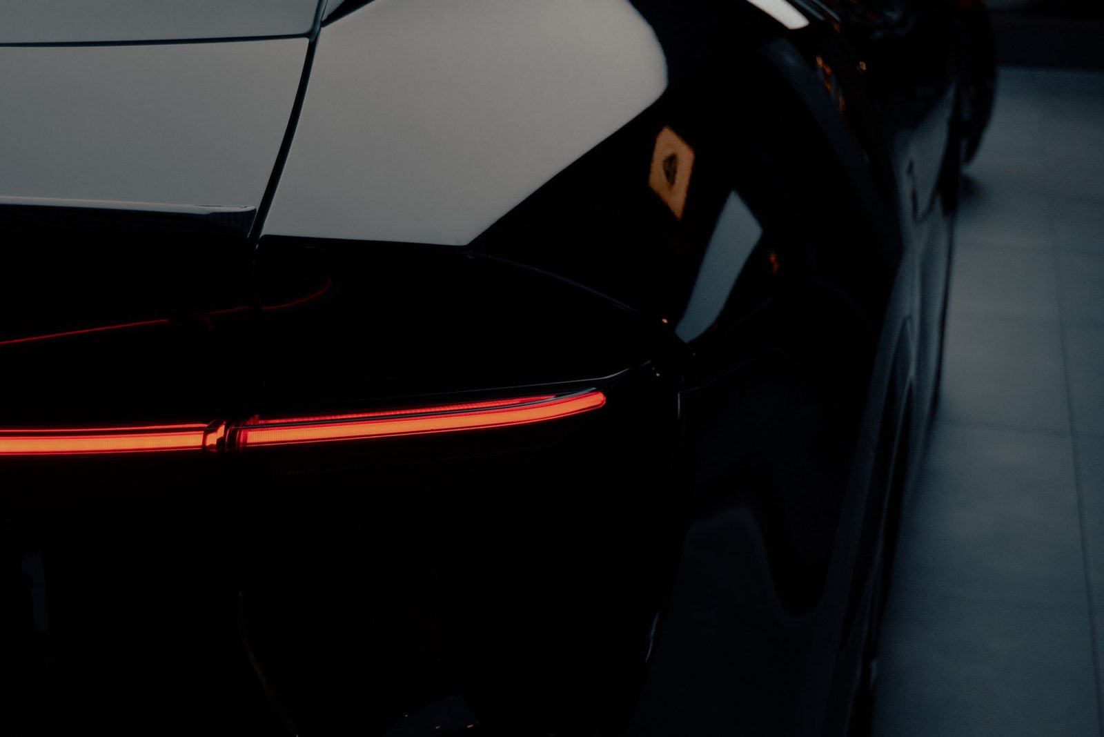 Sleek black car with red tail light after detailing