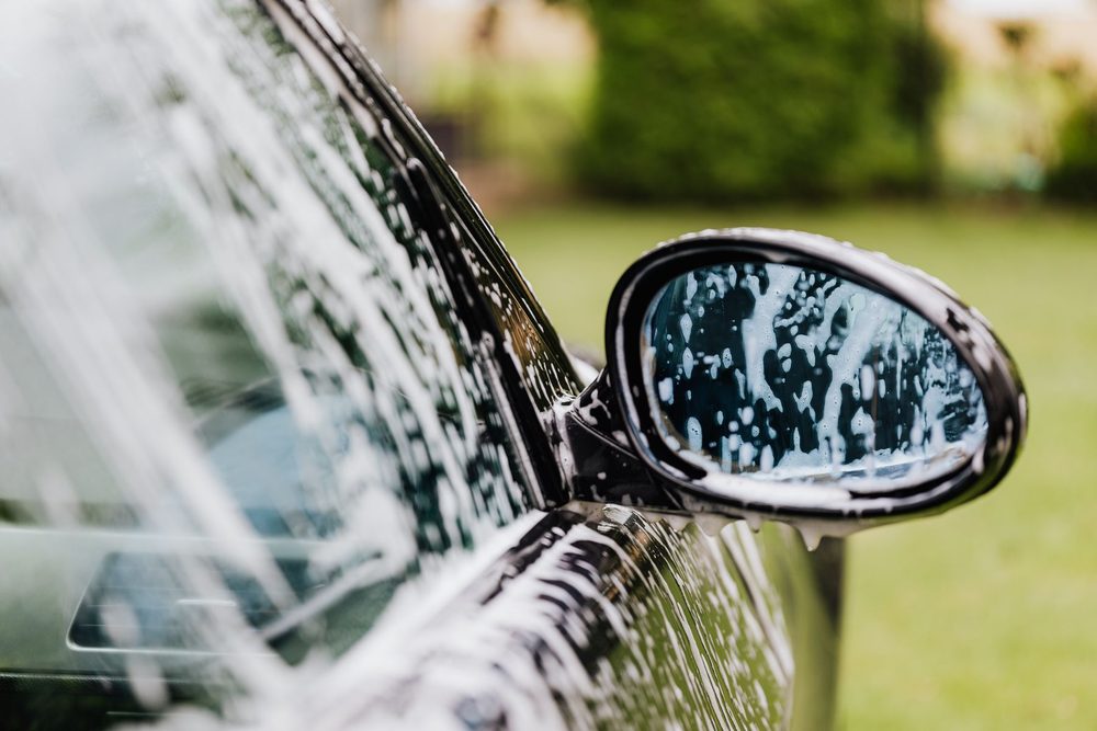 Suds on a side mirror during a wash