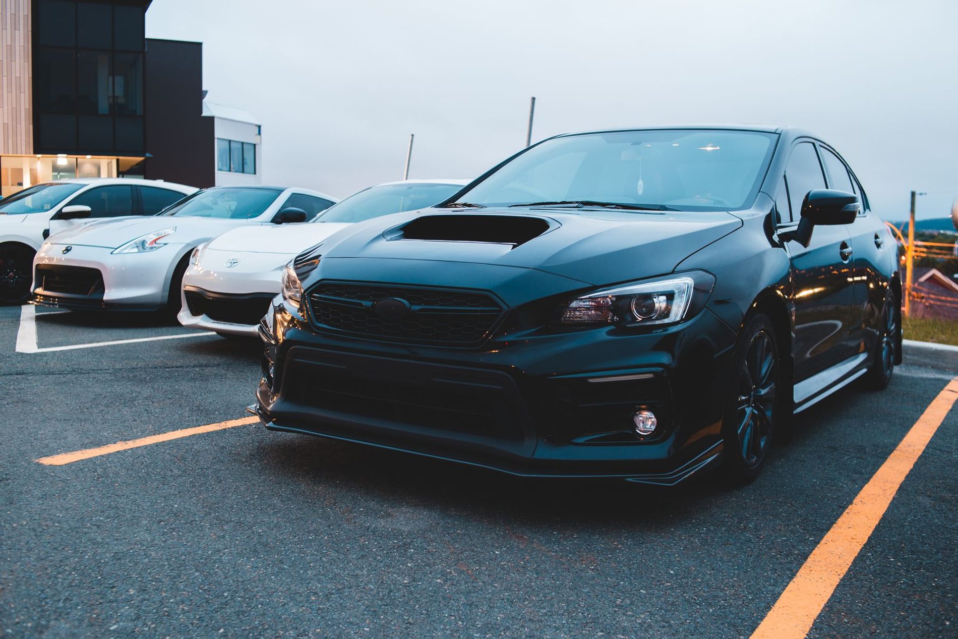 Deep black car with a mirror finish under a moody sky