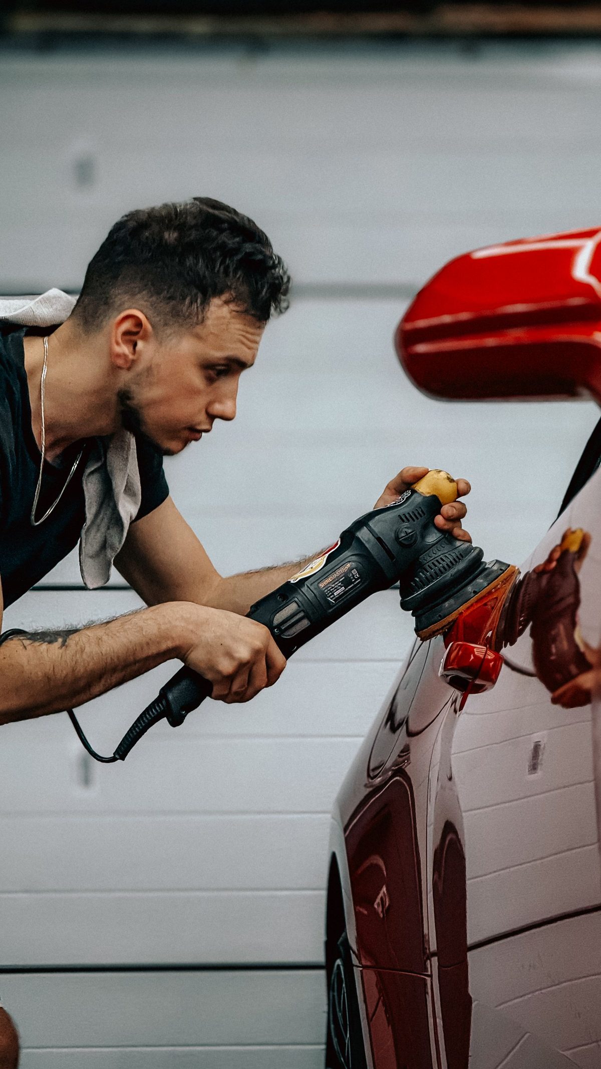Machine polishing a red car's paint