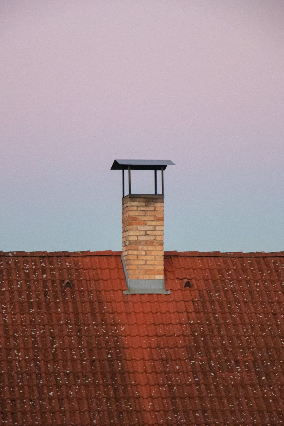 Brick chimney on a rooftop at twilight