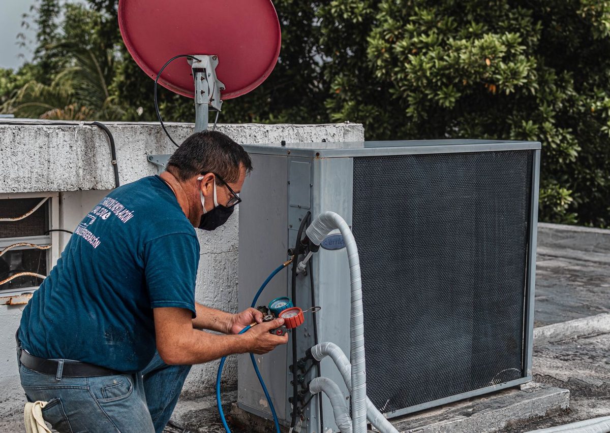 Technician servicing industrial rooftop HVAC equipment