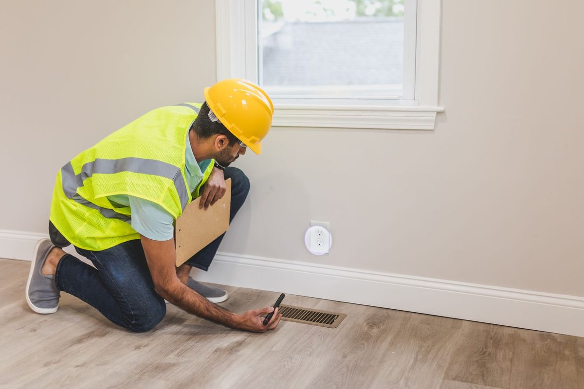Technician inspecting a home air vent