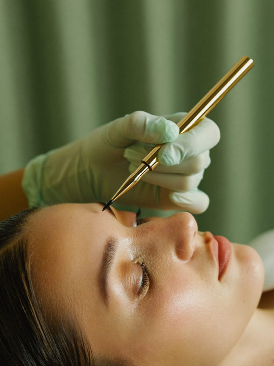 Permanent makeup artist working on brows